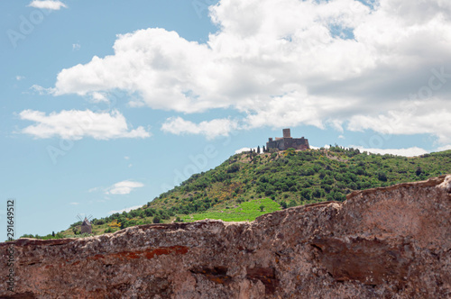 Fortress on a hill against the sky in a terrain with rocks