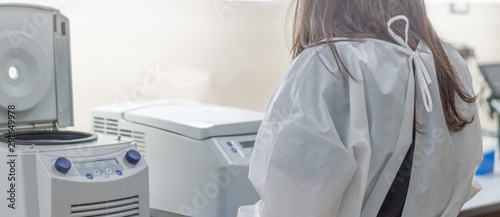 Scientist, worker, Laboratory technician using centrifuge device automation machine for testing and diagnostic clinical specimens sample in lab room of hospital. Medical science technology concept.