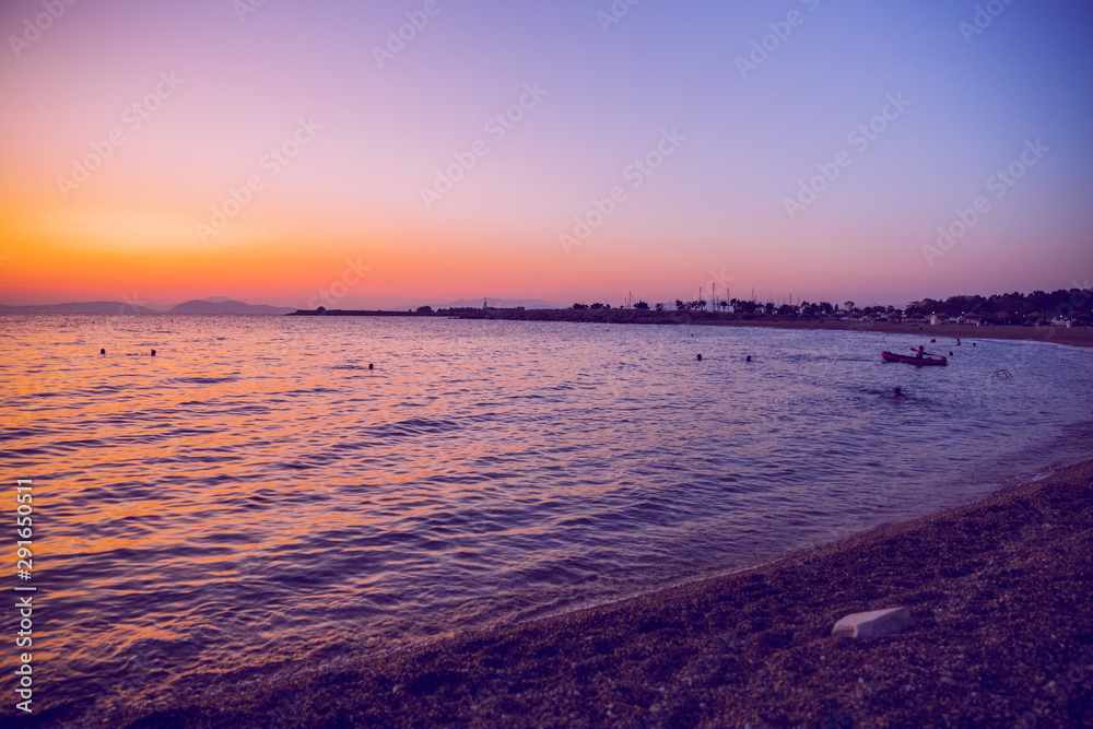 Obraz premium Greek Republic. Sunshine in sea and swimming people. In the distance mountains and sky. 17. Sep. 2019.