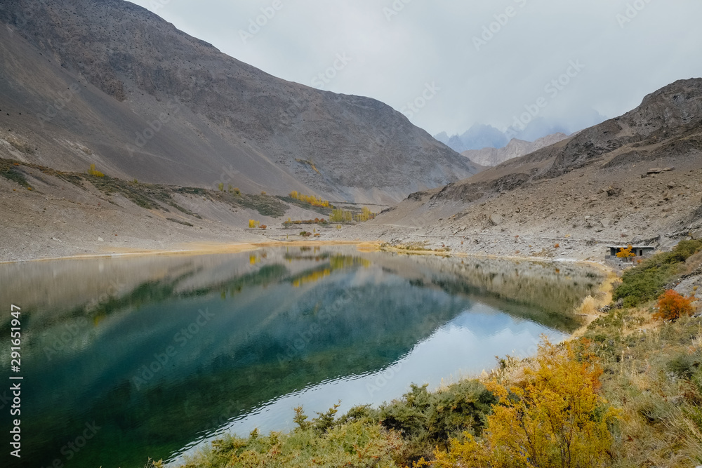 Beautiful landscape scenery of reflection in water of Karakoram mountain range at Borith lake. Autumn season in Gulmit Gojal, Hunza Valley. Gilgit Baltistan, Pakistan.