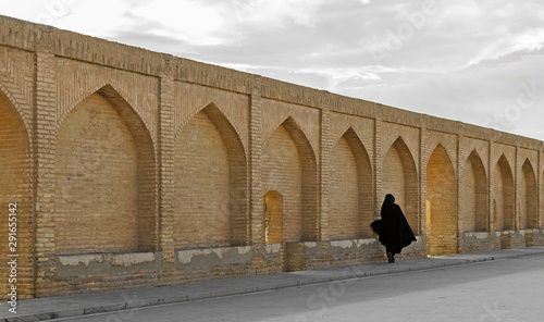 Veiled passenger on Siosepol bridge sidewalk, Isfahan, Iran photo