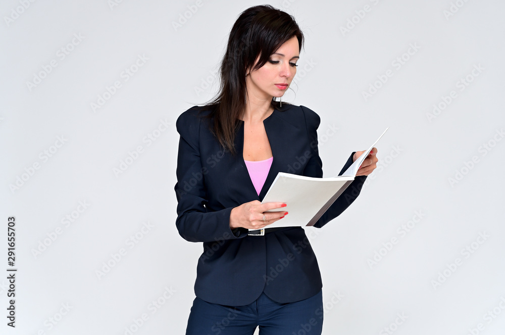 Portrait of a brunette manager woman in a business suit on a white background with a folder in her hands. Great makeup and beautiful hair. Standing right in front of the camera in various poses. Portrait of a brunette manager woman in a business suit on a white background with a folder in her hands. Great makeup and beautiful hair. Standing right in front of the camera in various poses.