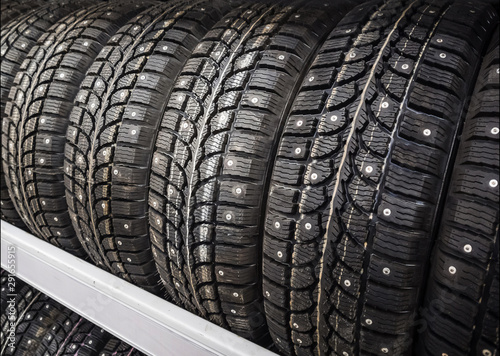 Winter car tires with spikes in a car shop. The concept of choosing tires for driving on snowy roads, safe driving in winter.