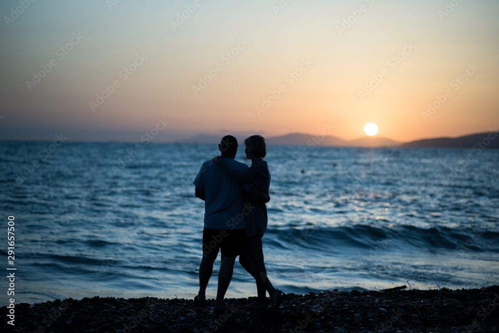 Silhouette of man and woman near the sea