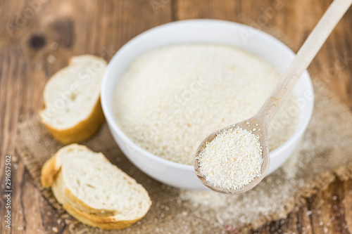 Breadcrumbs on a wooden spoon (close-up shot; selective focus)