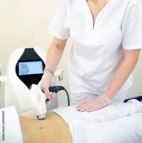 Woman gets laser and ultrasound treatment of face and body at medical spa, skin rejuvenation concept