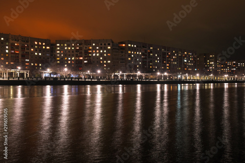 City embankment at night. Lights in the windows of apartments and lanterns. Winter is coming. © es0lex