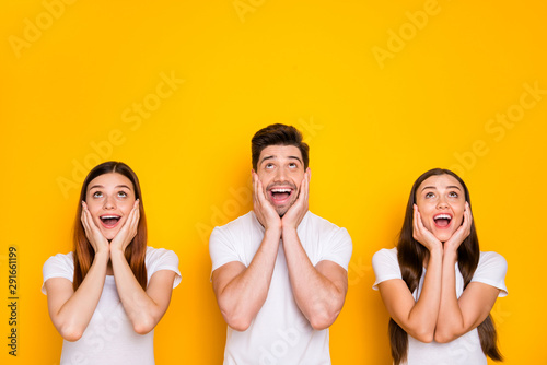 Portrait of three nice-looking attractive lovely cheerful cheery amazed person looking up expecting dream isolated over bright vivid shine yellow background