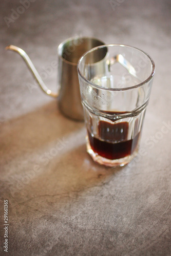 glass of drip coffee and beans on loft background
