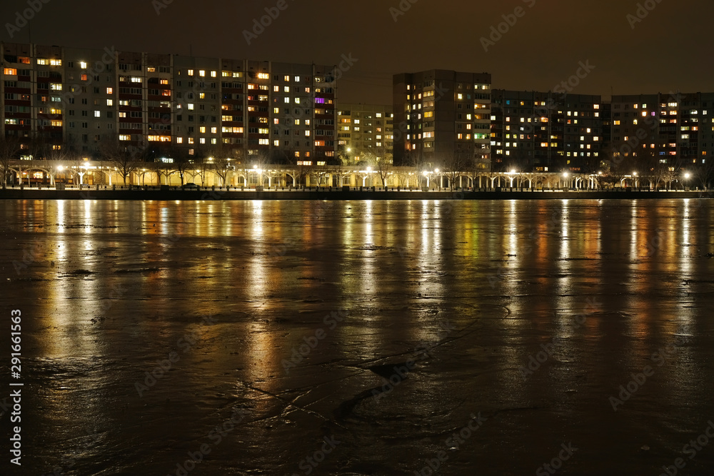 City embankment at night. Lights in the windows of apartments and lanterns. Winter is coming.