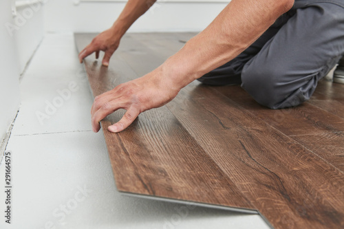 Foto worker joining vinyl floor covering at home renovation
