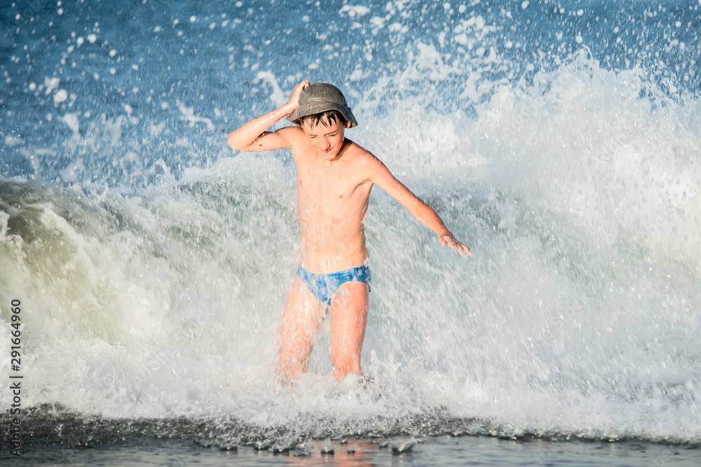 Boy in the spray of waves.