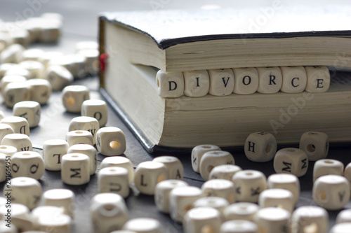 Word - Divorce made up of wooden letters on the table with wedding rings. photo