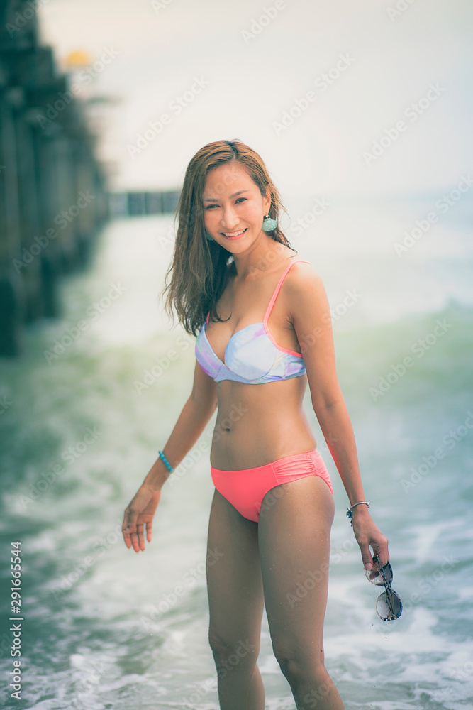beautiful asian younger woman wearing bikini on sea beach with smiling face  foto de Stock | Adobe Stock