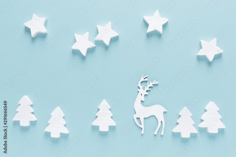 Fototapeta premium Christmas, New Year or Noel holiday farytail festive winter greeting card with decorations, deer, stars and x-mas fir trees on blue background, flat lay composition, top view, space for text