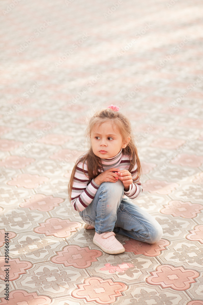little girl draws a chalk