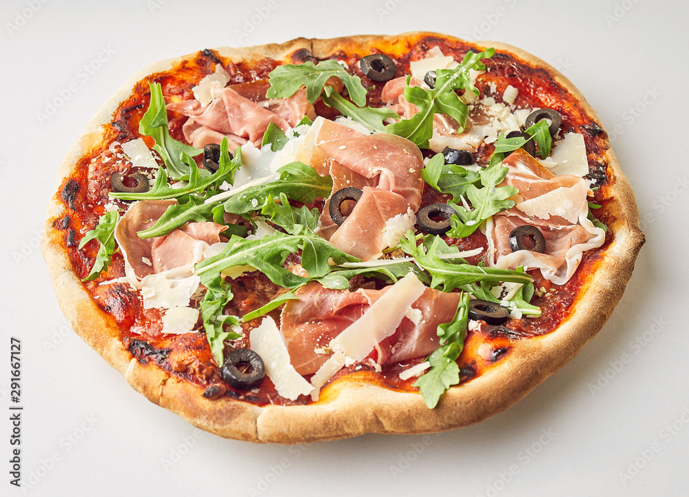 Tasty prosciutto, rocket and olive Italian pizza