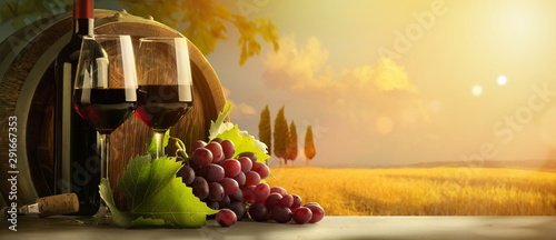autumn countryside wine background; vine, red wine bottles, wineglass, wine barrel; wine tasting concept
