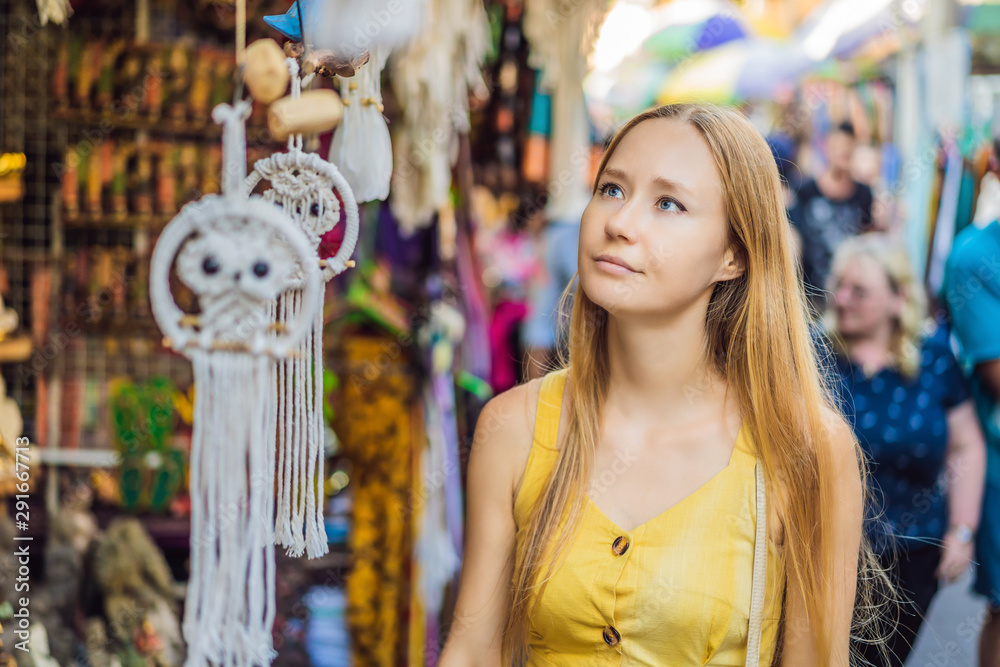 Obraz premium Woman traveler choose souvenirs in the market at Ubud in Bali, Indonesia