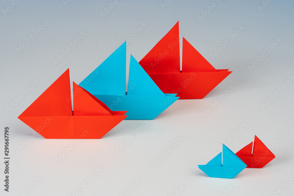 Paper boats. Concept - business size. Medium and small business. Ships made of paper of different sizes. Small versus large. Commonwealth based on sizes. Small companies versus corporations. Paper boats. Concept - business size. Medium and small business. Ships made of paper of different sizes. Small versus large. Commonwealth based on sizes. Small companies versus corporations.