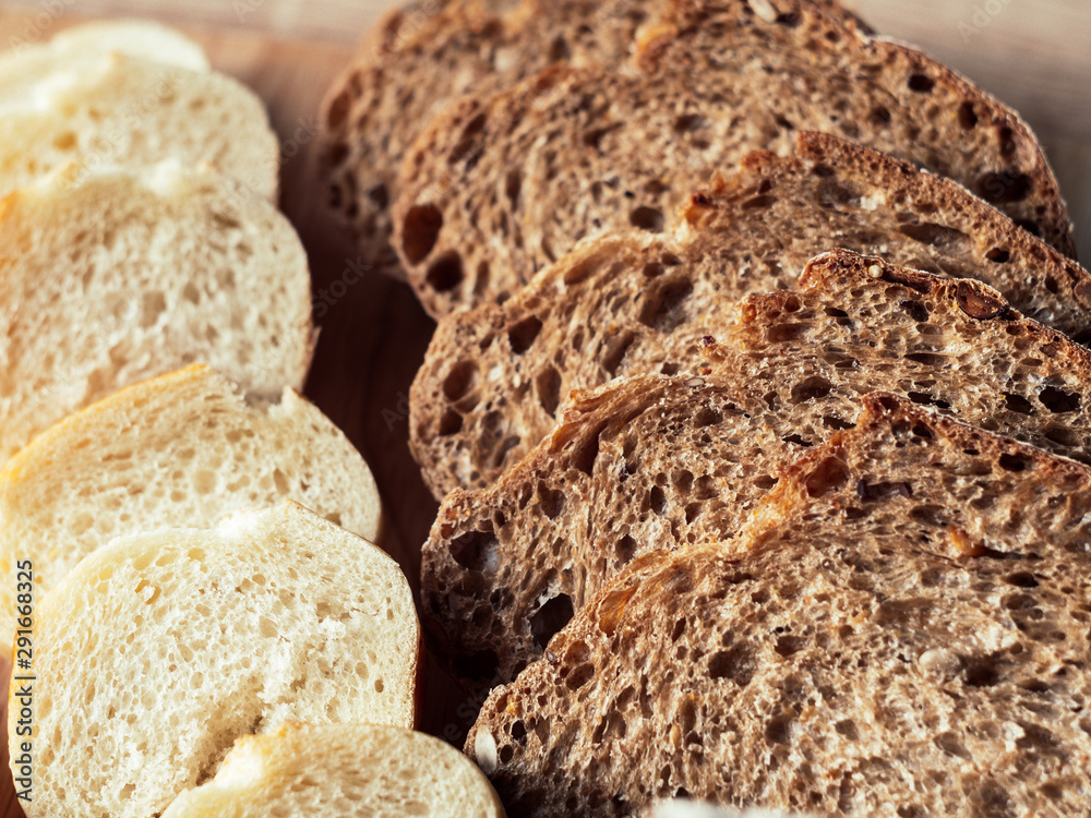 Fresh baked rye bread and sliced bread on rustic wooden board. Closeup.