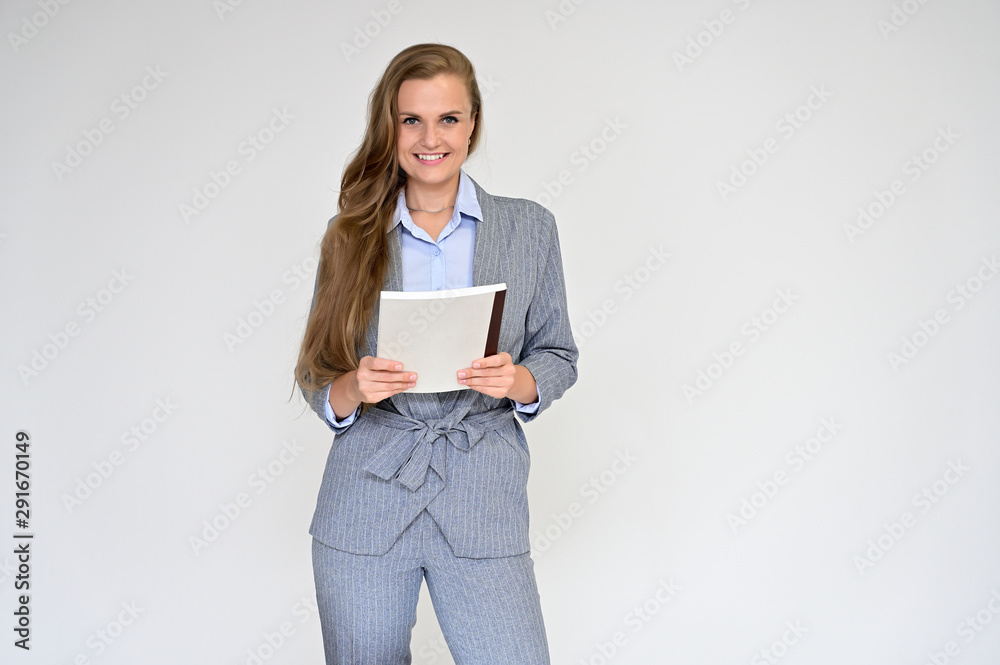 Portrait of a beautiful manager girl in a gray business suit on a white background with a folder in her hands. Stands in different poses with emotions. Portrait of a beautiful manager girl in a gray business suit on a white background with a folder in her hands. Stands in different poses with emotions.