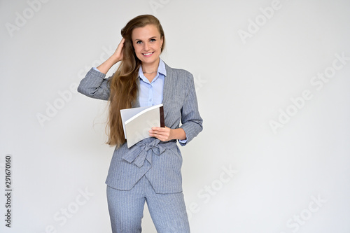 Portrait of a beautiful manager girl in a gray business suit on a white background with a folder in her hands. Stands in different poses with emotions. photo