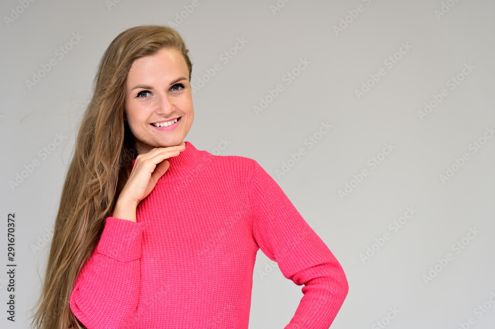 Close-up portrait of a beautiful girl with long hair in a coral sweater on a white background. Close-up portrait of a beautiful girl with long hair in a coral sweater on a white background.