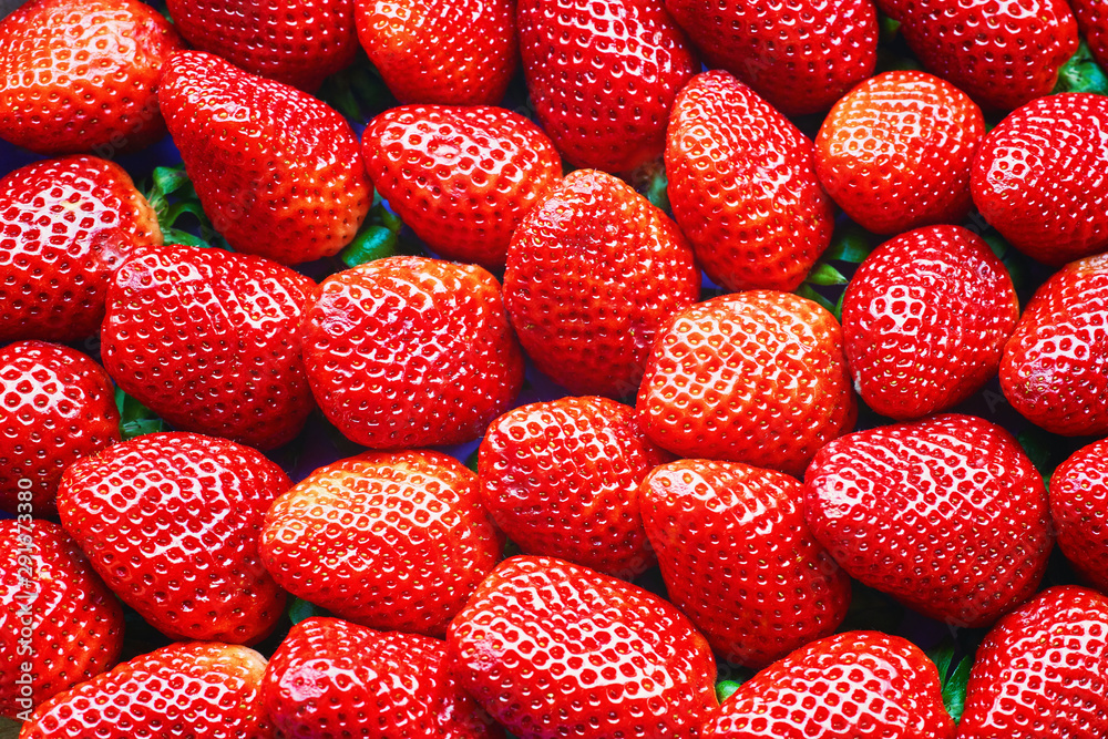 Freshly harvested strawberries directly above as a red background.