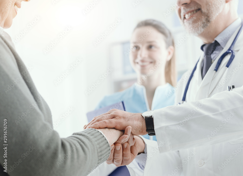 Professional doctor holding a senior patient's hands Professional doctor holding a senior patient's hands