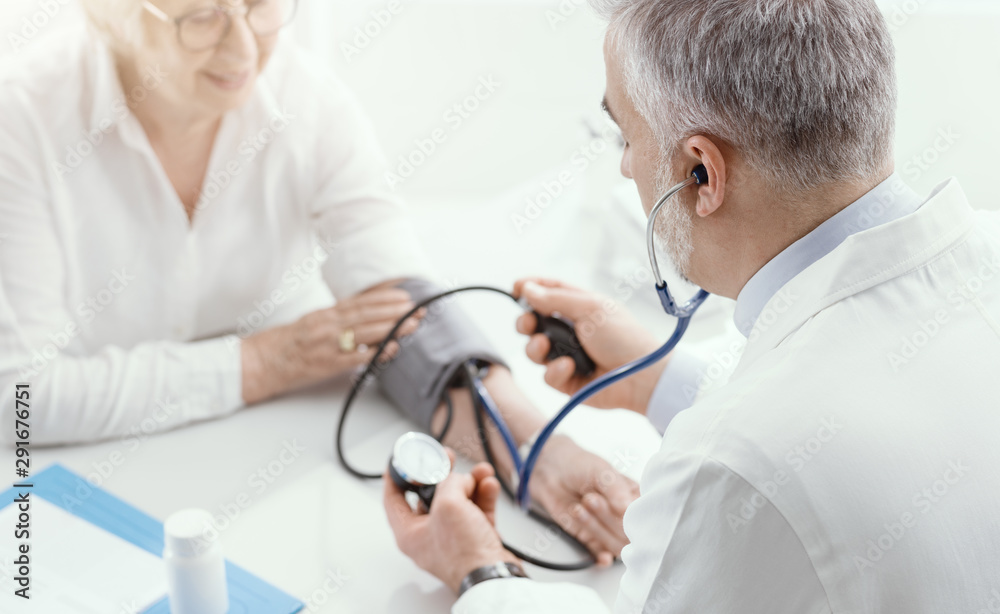 Doctor measuring blood pressure of a senior patient Stock Photo | Adobe ...