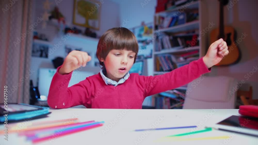 the child sits at a table, takes a pencil and begins to draw