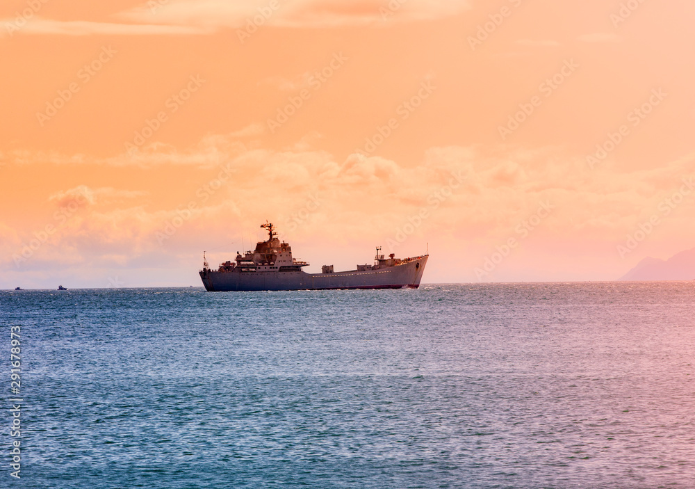 military ship on ocean at sunrise