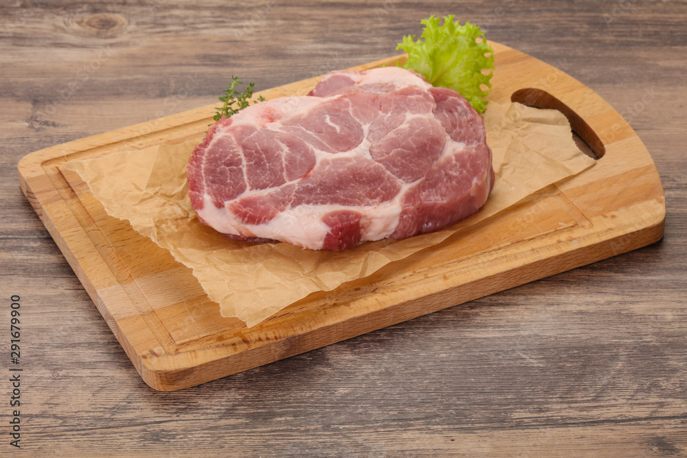 Raw pork steak over wooden board Raw pork steak over wooden board