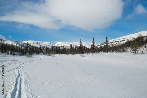 winter mountain landscape with a road and blue sky