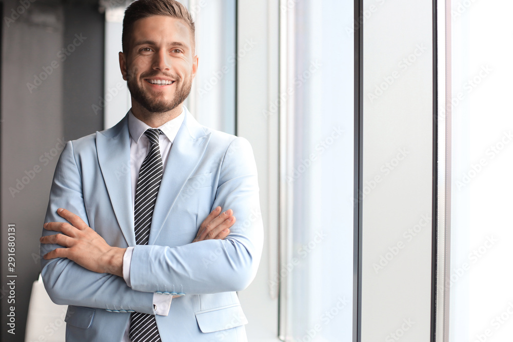 Portrait of happy businessman with arms crossed standing in office Portrait of happy businessman with arms crossed standing in office
