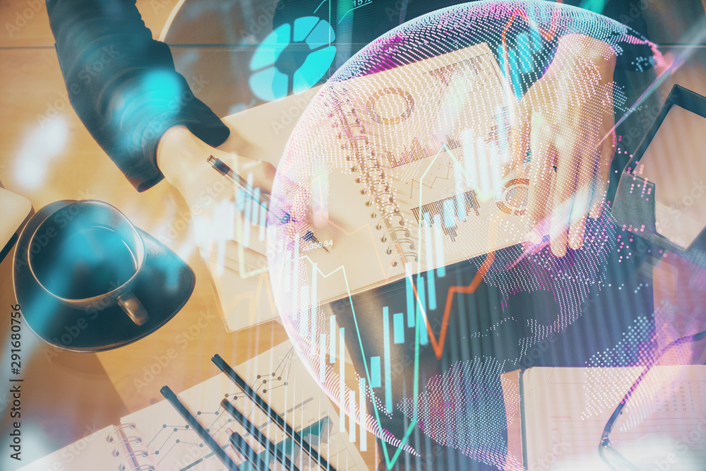 Double exposure of hands making notes with forex chart huds. Stock market concept. Double exposure of hands making notes with forex chart huds. Stock market concept.