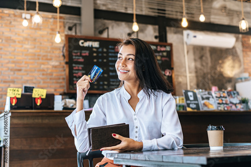 Accepting credit cards from a brown purse to pay for goods on coffee orders.