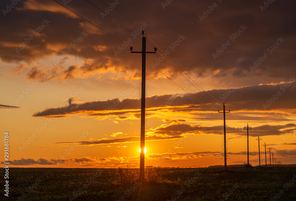Obraz premium Power line on the background of beautiful dramatic sunset . Electrical wires on poles