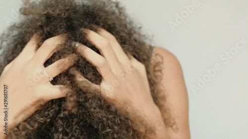 Slow motion of a black woman touvhing her afro hair. Closeup. photo