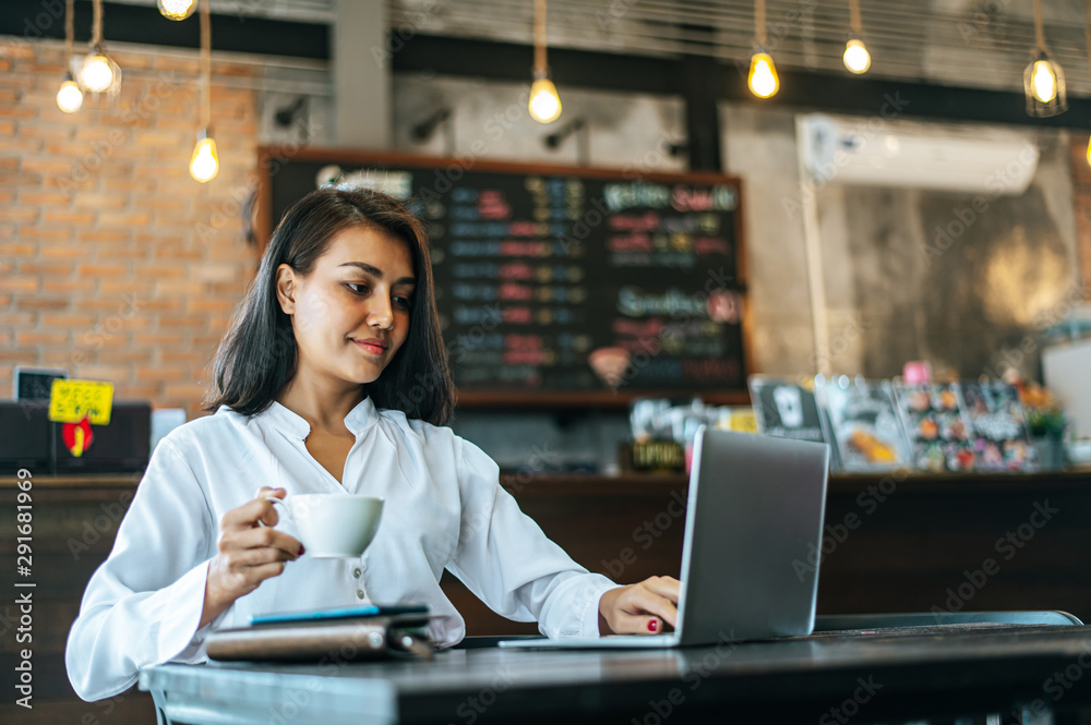 woman sitting and working with a laptop in a coffee shop