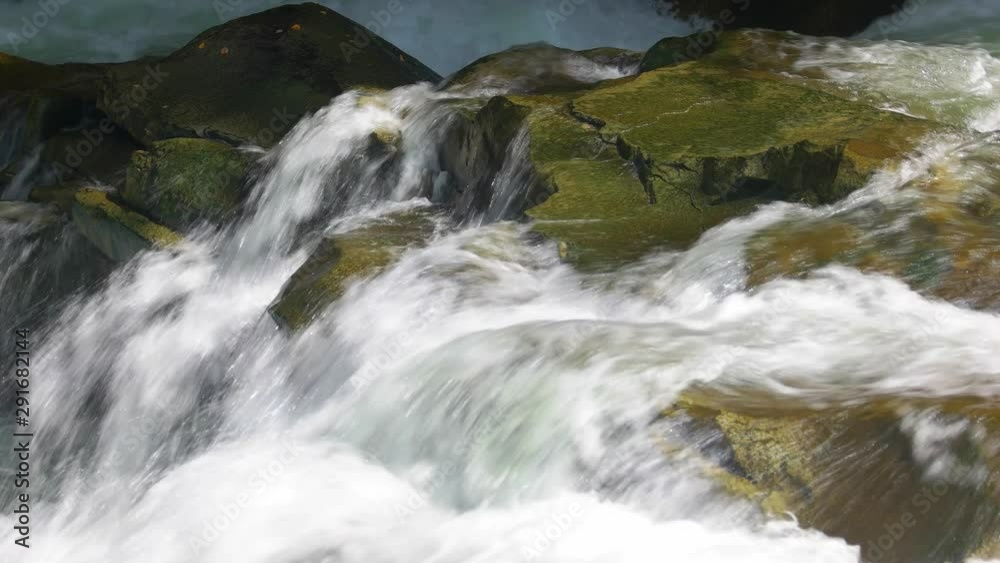 Pure water flows between stones. Powerful flow of mountain river close up. Pure water flows between stones. Powerful flow of mountain river close up.