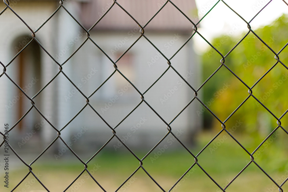 Country house in nature surrounded by a metal fence made of mesh for security against thieves and theft Country house in nature surrounded by a metal fence made of mesh for security against thieves and theft