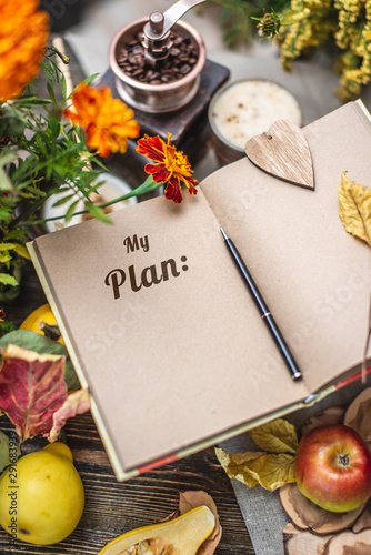 Autumn set of yellow leaves and flowers. Notebook with open pages on the table. Top view. Concept my plan