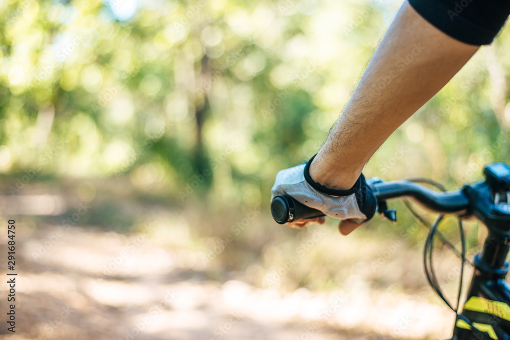 Naklejka premium Mountain cyclists grasp the bike handle, focus on gloves