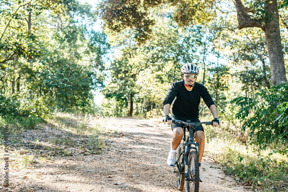 Naklejka premium The man riding a bike in a mountain path