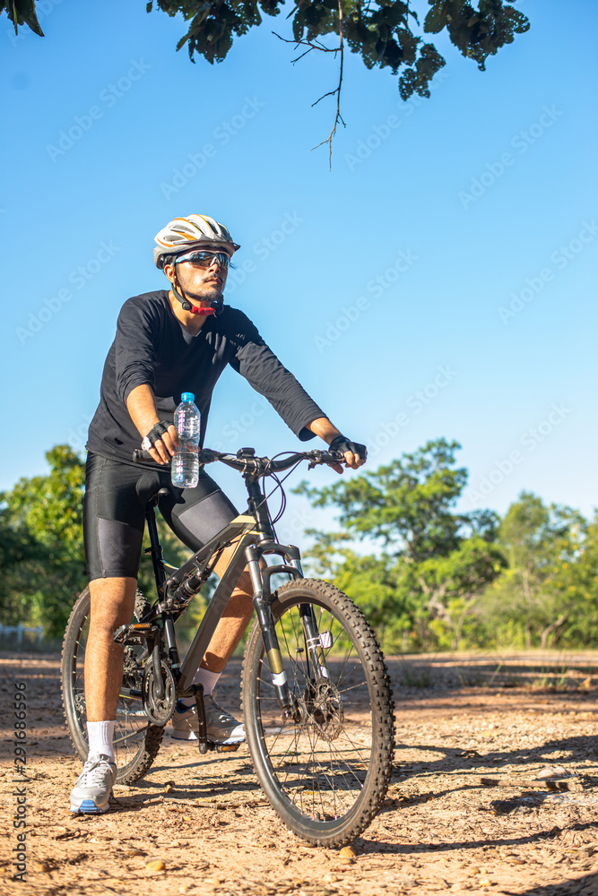 Mountain cyclists sit on bicycles and carry water bottles Mountain cyclists sit on bicycles and carry water bottles