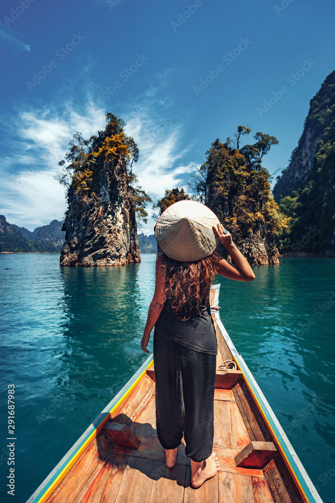 young woman tourist in asian hat on the boat at lake young woman tourist in asian hat on the boat at lake
