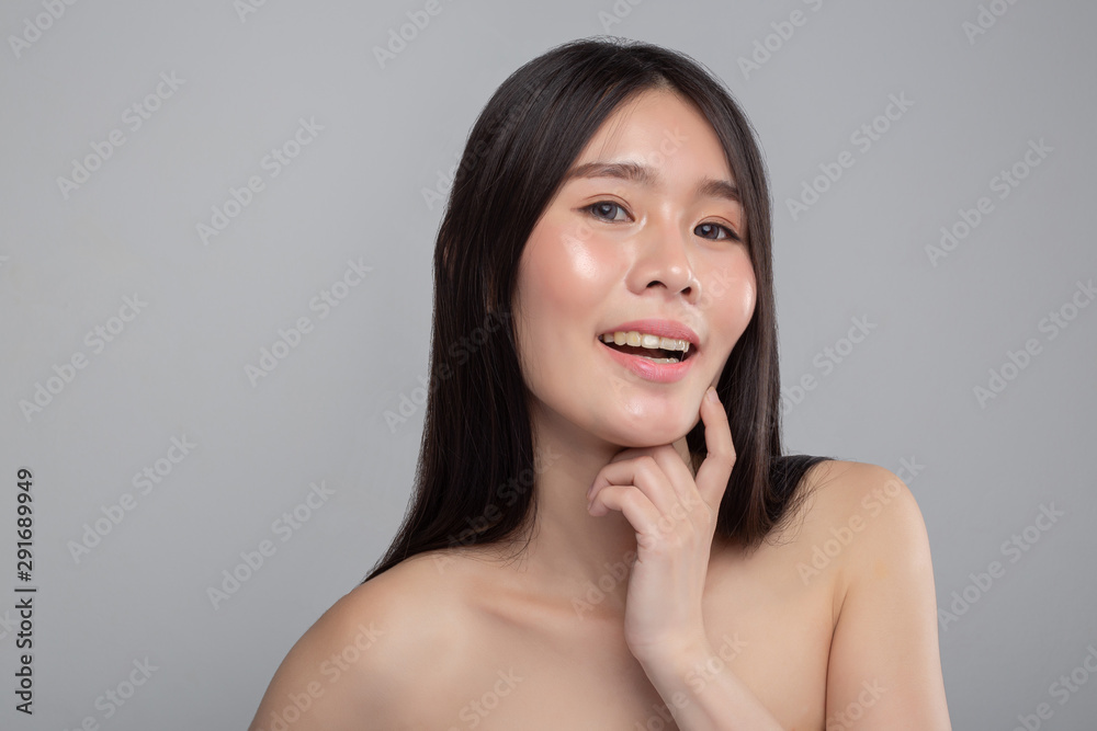 Woman wearing a white strapless dress and hands touching the chin.