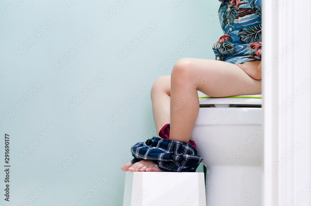 Kid sitting on toilet with low view of his legs hanging , copy space,  Training child or Health care concept Stock Photo | Adobe Stock